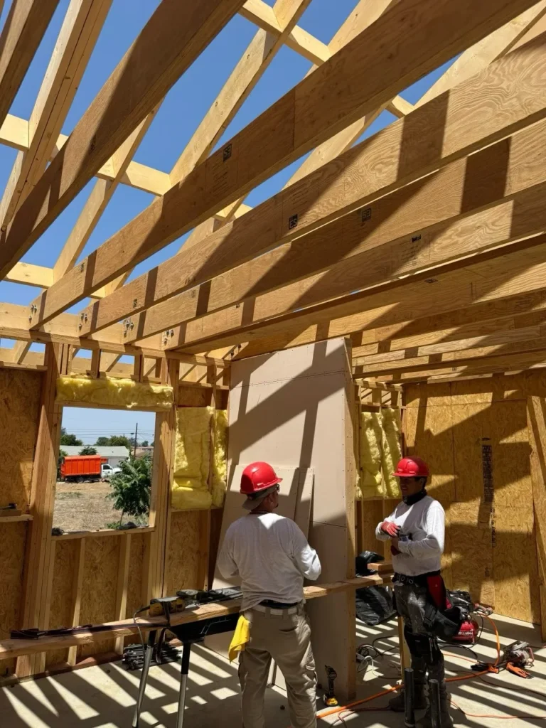 Construction team coordinating inside an ADU framing stage